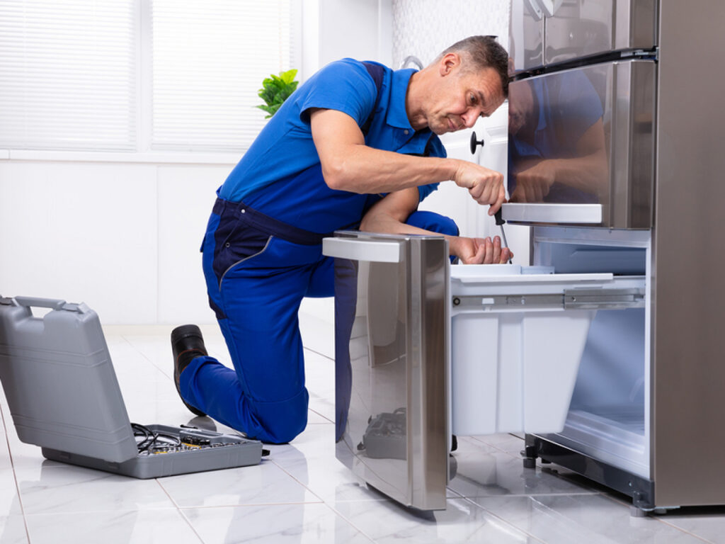 man working on refrigerator